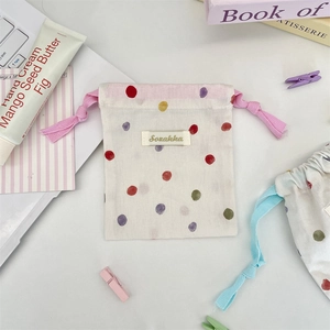 Flat lay of mini drawstring pouch with colorful polka dots and pink cotton rope