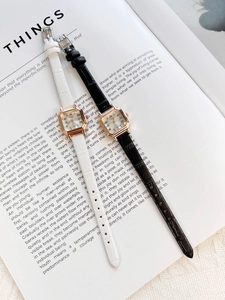 Elegant square women's watches with leather straps displayed on a fashion magazine