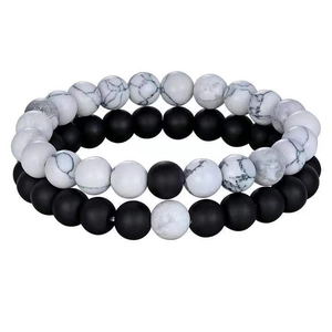 Macro detail of natural white turquoise and black lava stone beads on stretch bracelets