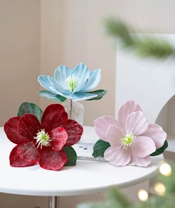 Detailed view of artificial Christmas lotus flowers with glitter on a white table