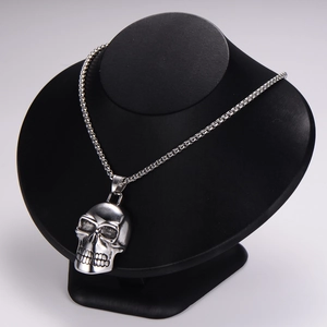 Macro shot of silver stainless steel skull pendant with tight metal weave chain on neck model