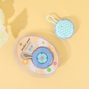 Blue silicone scalp massager brush with flower pattern and retail packaging detail