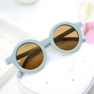 Detail of light blue round frame kids sunglasses with UV400 and CE certification markers