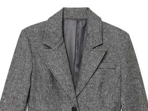 Detail of grey herringbone tweed blazer showing lapel texture and fabric weaving patterns