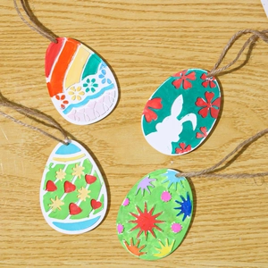 Detail of four Easter egg ornaments with bunny and heart patterns on wood background