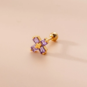 Detalle macro de pendiente de cruz dorada con piedras de circonita púrpura cuadrada