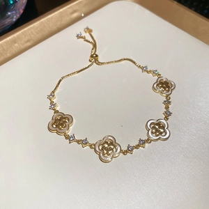 Détail d'un bracelet doré à trèfles à quatre feuilles avec nacre et zircons brillants