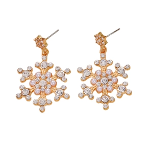 Detail of gold snowflake earrings with sparkling rhinestones and pink pearls