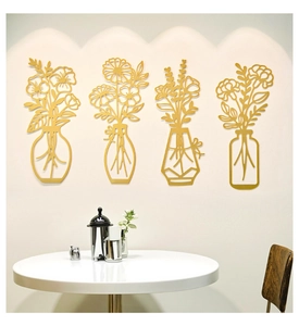 Detalle de cuatro piezas de arte de pared en metal dorado mate con diseños de flores zen