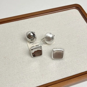 Set of vintage matte silver square and round open rings on a white textured display board