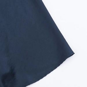 Vue macro de la texture du tissu en satin bleu foncé et détails de couture d'une robe