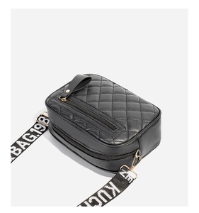 Detail of quilted camera bag with wide letter print strap and gold-tone zippers