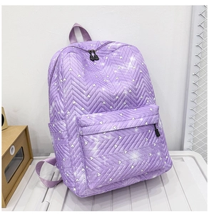 Primer plano de mochila acolchada morada con patrones de corazones blancos y cremallera