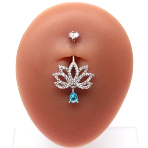 Detail of lotus navel piercing with light blue teardrop gemstone on silicone model