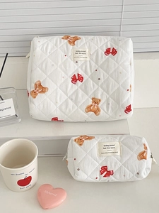 Close-up of quilted cosmetic bags featuring bear and bow patterns in a set of two