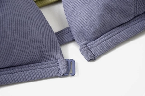 Macro detail of ribbed knit fabric and matching hook closure on lilac wireless bra