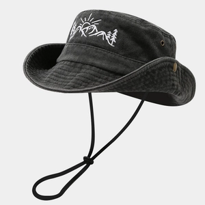 Detailed close-up of mountain embroidery and washed canvas texture on the black outdoor hat
