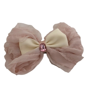 Ballet style cream pink mesh bow hair clip with a center gemstone on white background