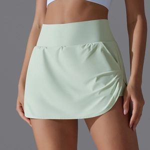Close-up of mint green high-waisted tennis skort with side ruching and pocket detail