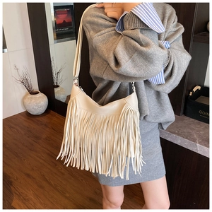 Detail showing cream white tassel design on bohemian style PU leather shoulder bag for women