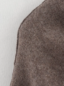 Close-up macro view showing the brown wool fabric texture and fiber details of the coat