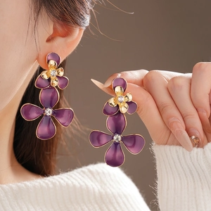 Elegant purple enamel flower earrings with gold plating and sparkling crystal centers