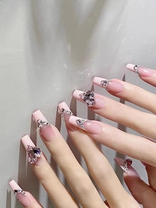 Detailed close-up of pink heart rhinestone on long coffin shape gradient fake nails