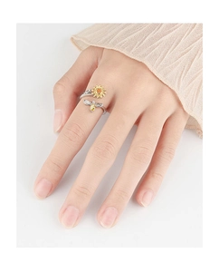 Detailed close-up of a silver sunflower and bee spinning ring on a model hand