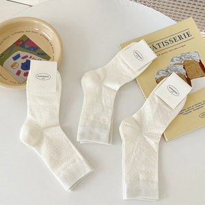 White cotton hollow out mid-calf socks with bow tie design in elegant setting