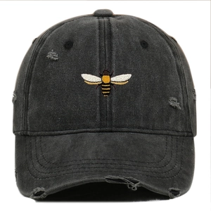 Detailed view of bee embroidery and distressed design on washed charcoal baseball cap