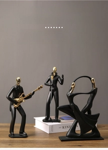 Vue détaillée de figurines de musique noir mat et or posées sur un bureau en bois