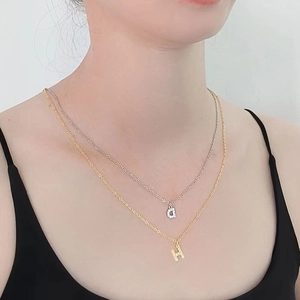 Collier double rang avec pendentif lettre H serti de zircons et petites breloques