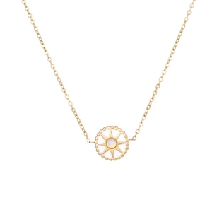 Macro detail of gold-plated compass star necklace with opal-like inlay and bead edge