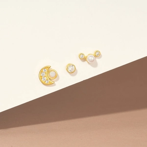 Detailed view of gold earrings set featuring moon opal, pearl, and crystal studs