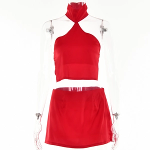 Detailed view of the red halter neck top and slit skirt set on a transparent mannequin