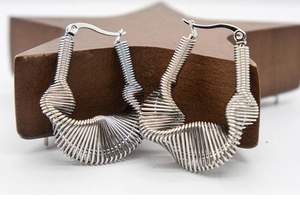 Macro shot of silver multi-layered wire wrap geometric earrings on a wooden background
