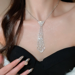 Macro shot of a sparkling crystal tie-shaped necklace with fringes on model