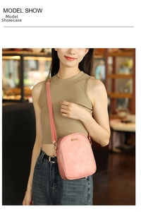 Borsa a tracolla rosa in pelle cerata indossata da una modella con dettagli dorati
