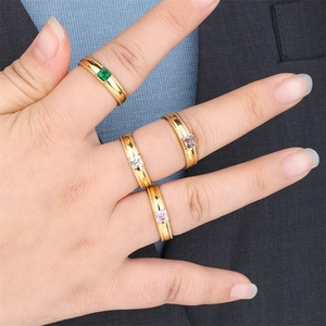 Close-up of four gold stainless steel rings with square colorful zircon stones on hand