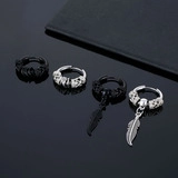 Detail of vintage steel hoop earrings with feather pendants in black and silver