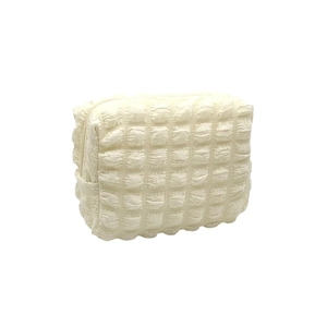 Creamy white bubble textured makeup bag with zipper closure for travel storage