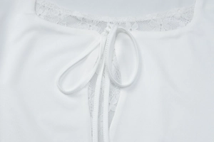 Detailed close-up of white lace stitching and bow tie neck on a square collar top