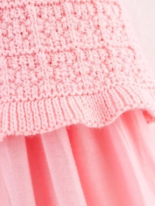 Detailed macro shot of pink knit fabric stitching and refined material texture