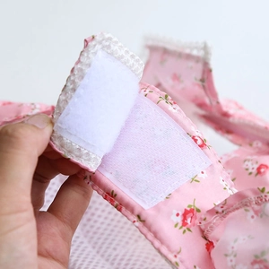 Close-up of pink floral pet harness featuring secure white hook and loop fastener detail