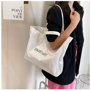 Detail of transparent PVC tote with white fabric inner bag and Skillfully text