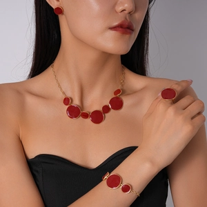 Vue détaillée d'une parure de bijoux en émail rouge avec collier, boucles et bague sur mannequin