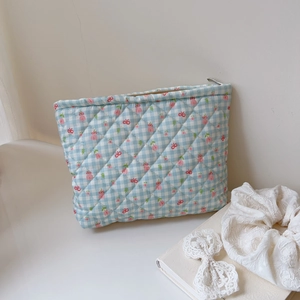 Detailed close-up of light blue quilted cotton toiletry bag with tulip floral pattern