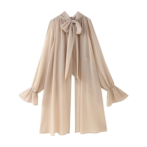 Detail of elegant chiffon blouse featuring ribbon bow collar and flared ruffle cuffs
