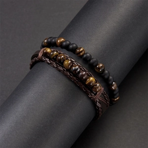 Close-up of braided leather cord and tiger eye stone bead bracelets for men
