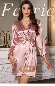 Detailed view of pink satin robe with black piping detail in a luxury bathroom setting